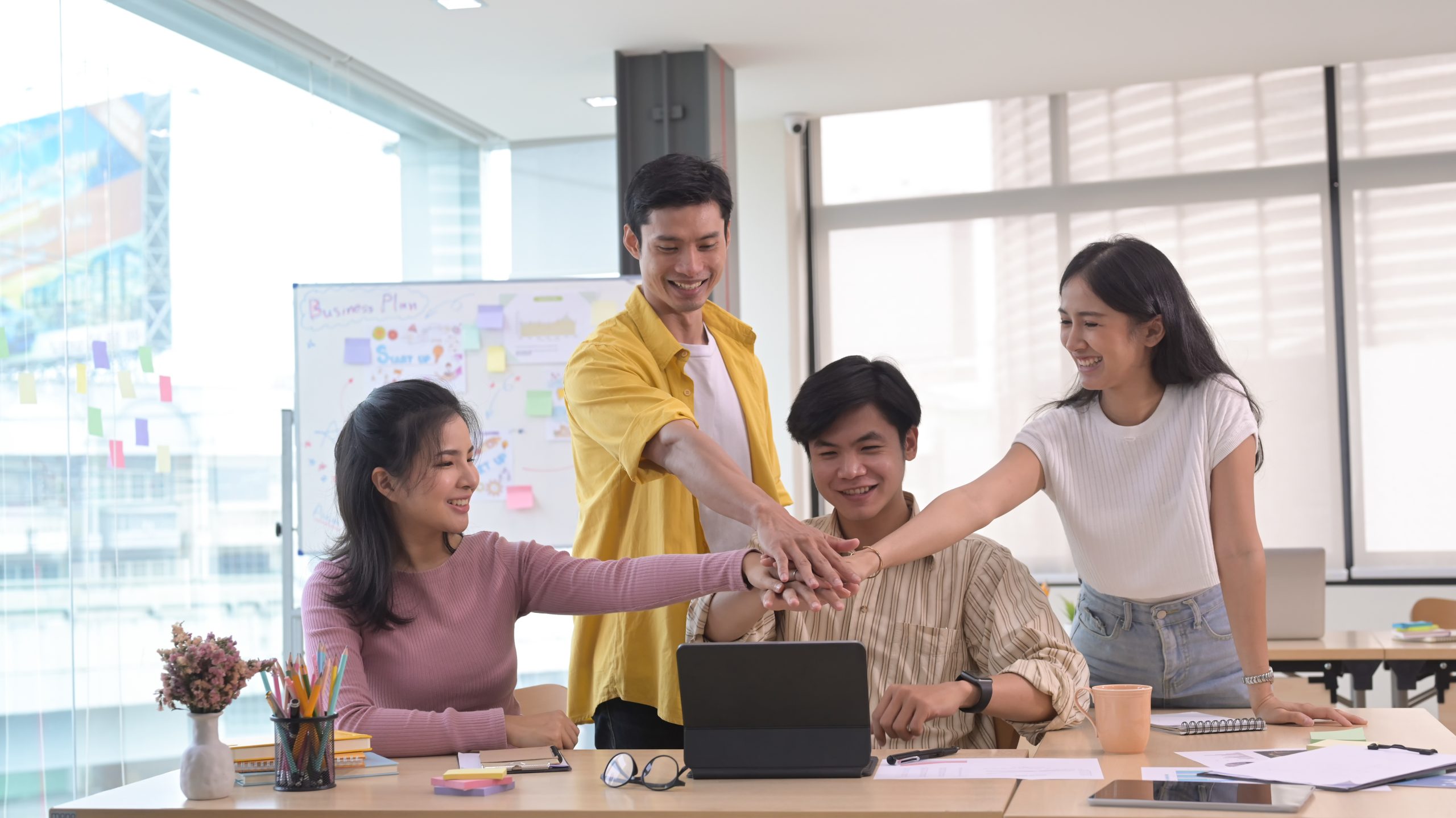Successful business team joining fists each other, showing suppo